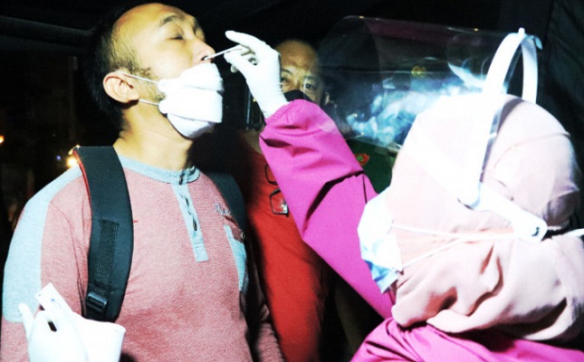 Salah satu pengendara yang ingin masuk ke Kota Banjarmasin melalui Pos PPKM Km 6 dilakukan pemeriksaan test swab antigen.